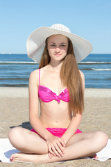 attractive woman in pink bikini sitting on the beach