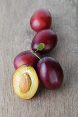 three ripe plums with leaves