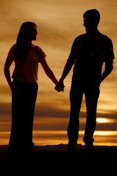 Silhouette of man and woman holding hands