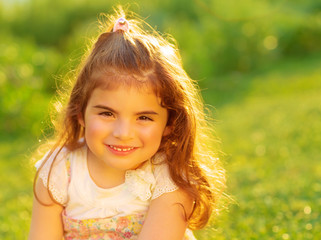 Cute little girl on green field