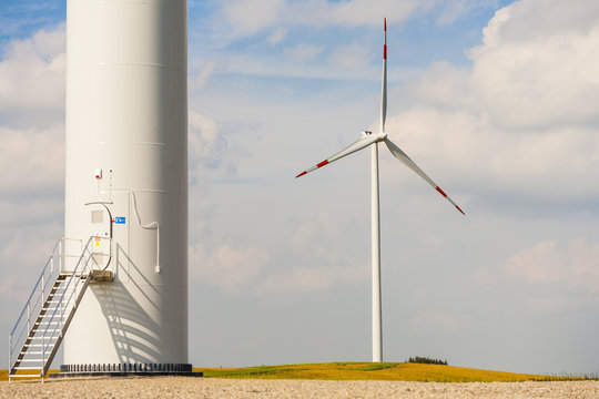 The base of the wind turbine, wind turbine in background.
