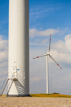 The base of the wind turbine, wind turbine in background.