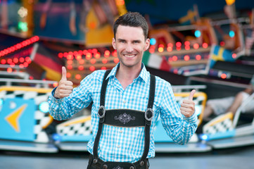 Young man wearing traditional Bavarian Lederhosen with thumbs up