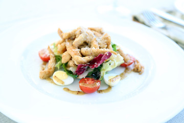 Caesar salad on white plate, close up
