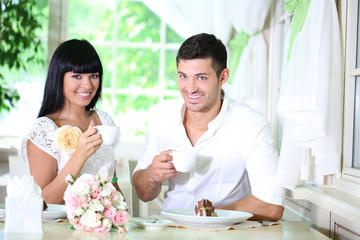 Obraz na płótnie Canvas Beautiful young romantic couple at cafe
