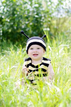 happy baby in bee costume outdoors
