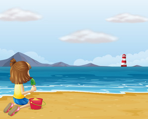 A young girl playing with the sand in the beach