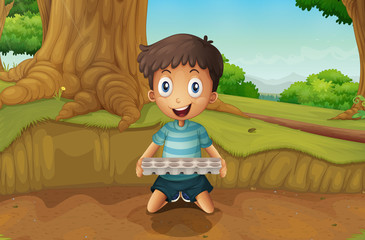 Obraz na płótnie Canvas A boy holding an eggtray in the forest