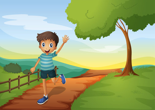 A young boy waving his hand while running