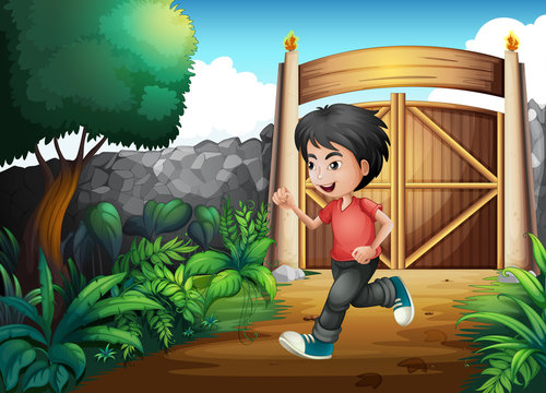 A boy with a red shirt running inside the fence