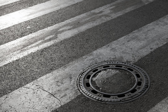 Sewer manhole cover on asphalt road