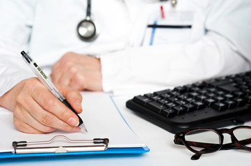 Cropped image of a physician writing prescription