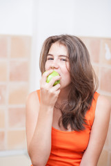 Beautiful teenage girl biting an apple