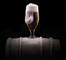 Frosty glass of light beer on black background