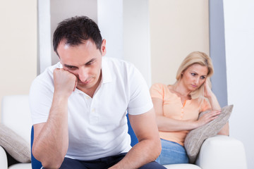 Angry couple sitting on sofa