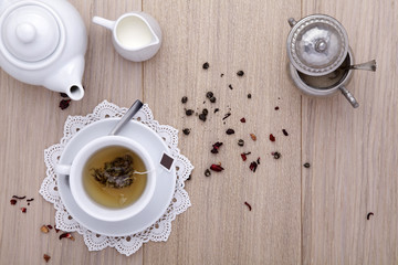 Fototapeta na wymiar filiżanka herbaty z czajnik, mleka, cukru, na drewnianym tle