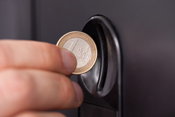 Human hand inserting coin