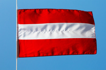 Austrian flag in the wind against a sky