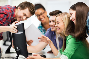 students looking at computer monitor at school