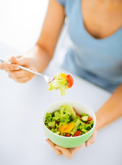 Obraz na płótnie Canvas woman eating salad with vegetables