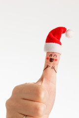 Finger dressed in Santa-Claus red-white hats