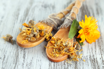 Fototapeta na wymiar Fresh and dried calendula flowers on wooden background