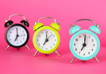 Colorful alarm clock on pink background
