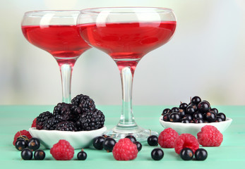 Jelly with fresh berries on green wooden table