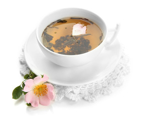Cup of herbal tea with hip rose flowers, isolated on white