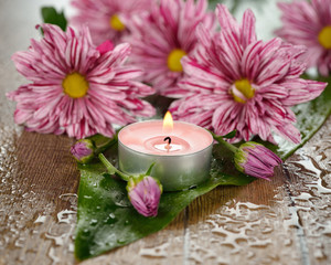 Burning candle and flowers