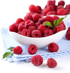 Ripe sweet raspberries in bowls, isolated on white
