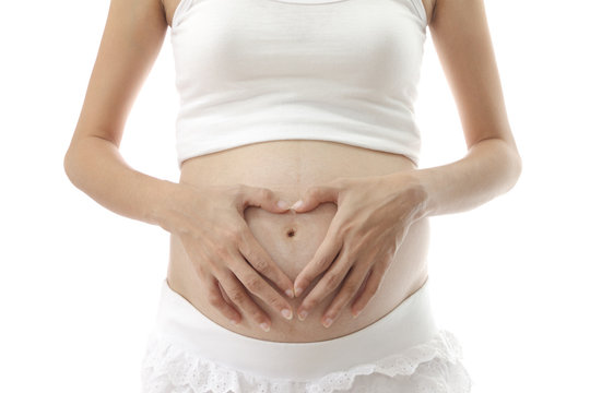 Hand on abdomen of pregnant woman on white background.