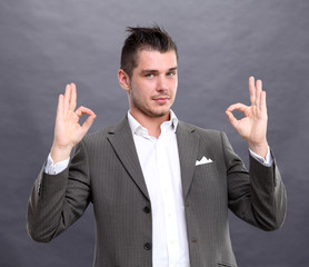 Happy smiling young business man with thumbs up gesture