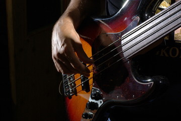 Fototapeta premium Man playing an bass guitar with brown body
