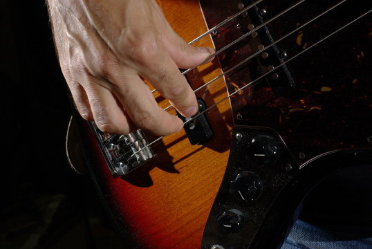Man playing an bass guitar with brown body