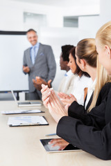 Businesspeople Clapping For A Man In Meeting