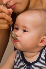 The small child, eats from a spoon