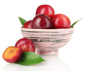 Ripe plums in bowl isolated on white