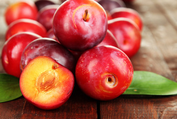 Ripe plums on wooden table close-up