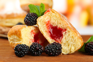 Tasty donuts with berries on wooden table