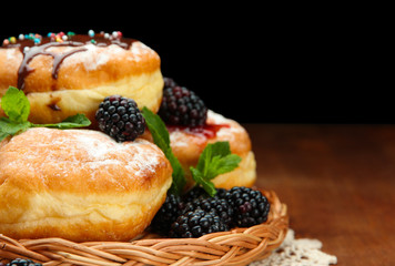 Tasty donuts with chocolate and berries on wooden table