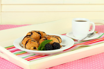 Wooden tray with breakfast, on wooden table, on light