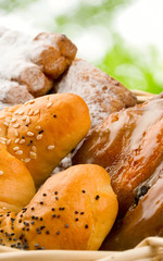 Basket of buns on green leaves background