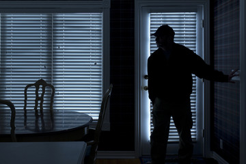 Burglar Breaking In To Home At Night Through Back Door - 54848601