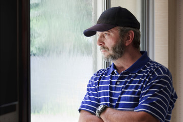 Adult Male Ponders Future Looking Out Rain Covered Window
