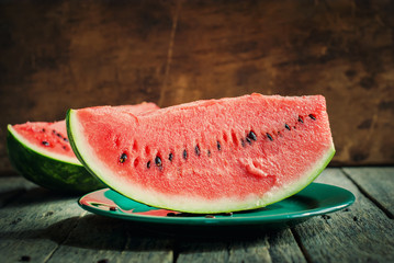 A Slice of Water-melon on a plate, wooden background