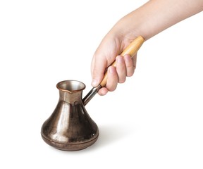 Hand holding copper turkish coffee pot, isolated on white