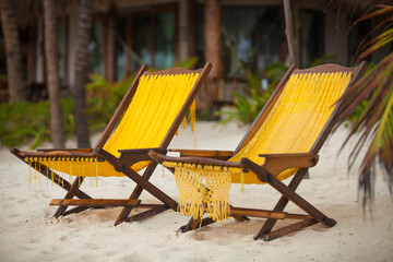 Two beach chairs on perfect tropical white sand beach in Tulum,