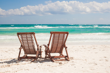 Beach wooden chairs for vacations on tropical beach in Tulum,