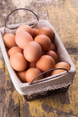 Eggs in bucket on wooden background